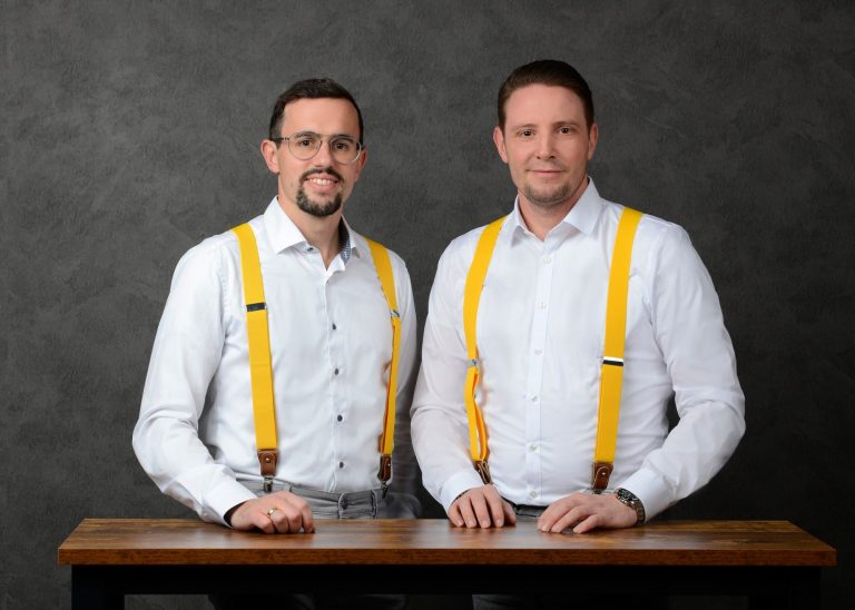 Foto von Andreas Langer und Marcus Mößinger hinter einem Tisch stehend